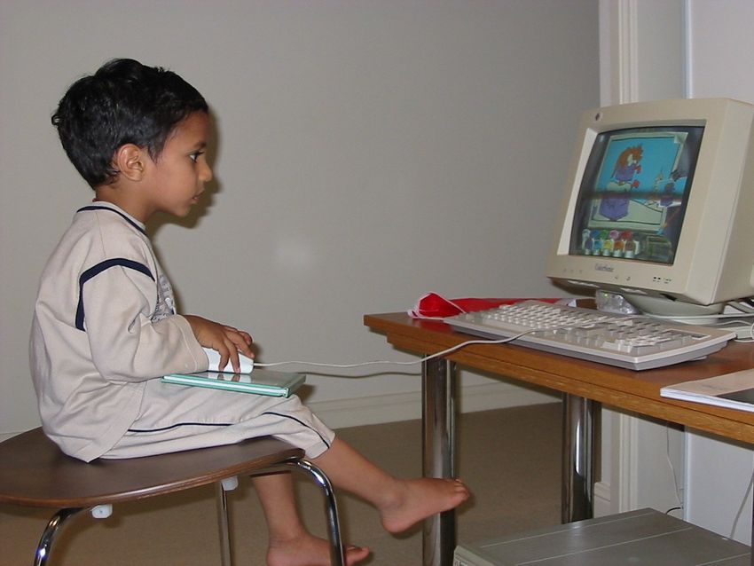Sandy as a small child sitting at a desktop computer